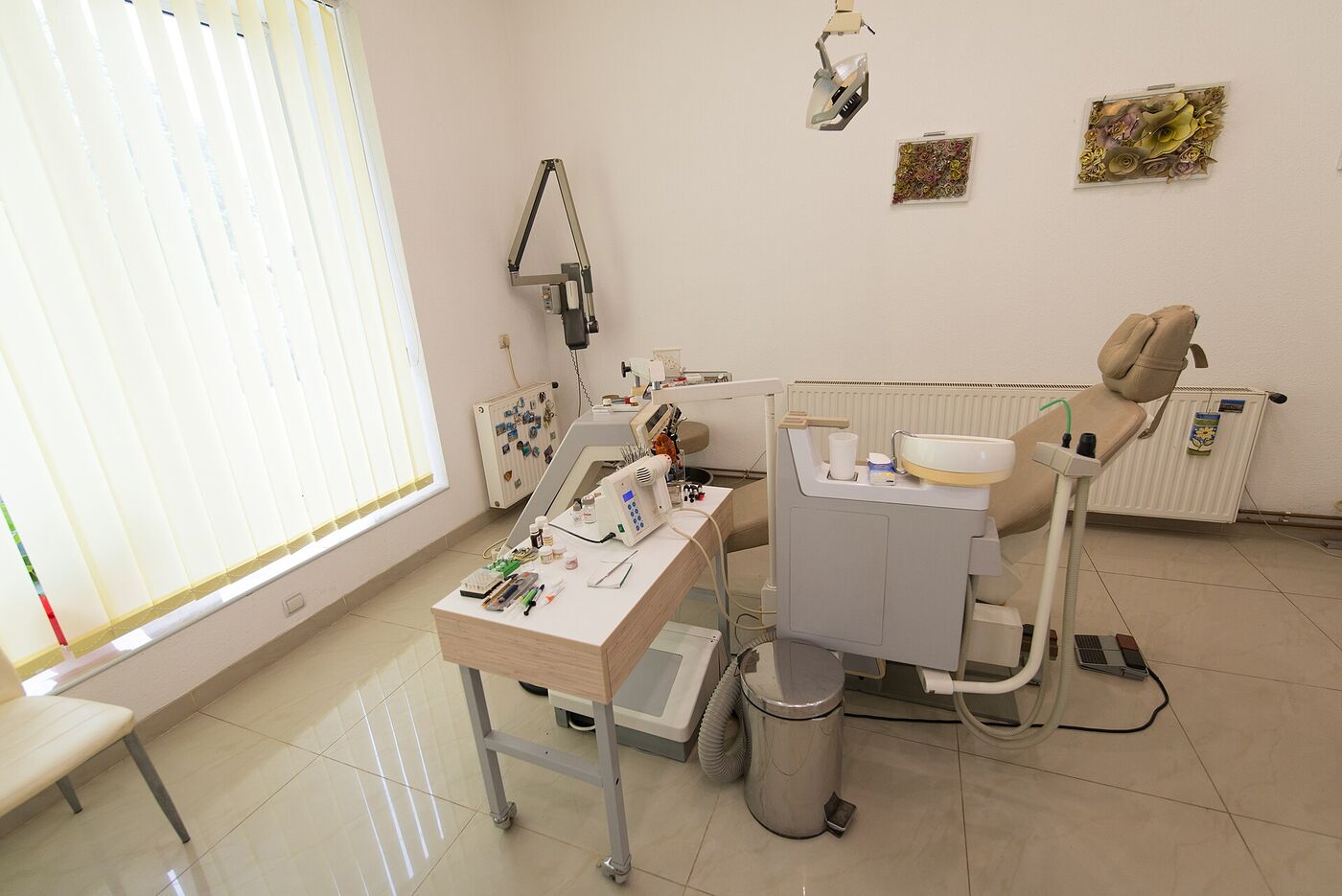 Representative stock photo of a dental treatment room with chair, light and equipment